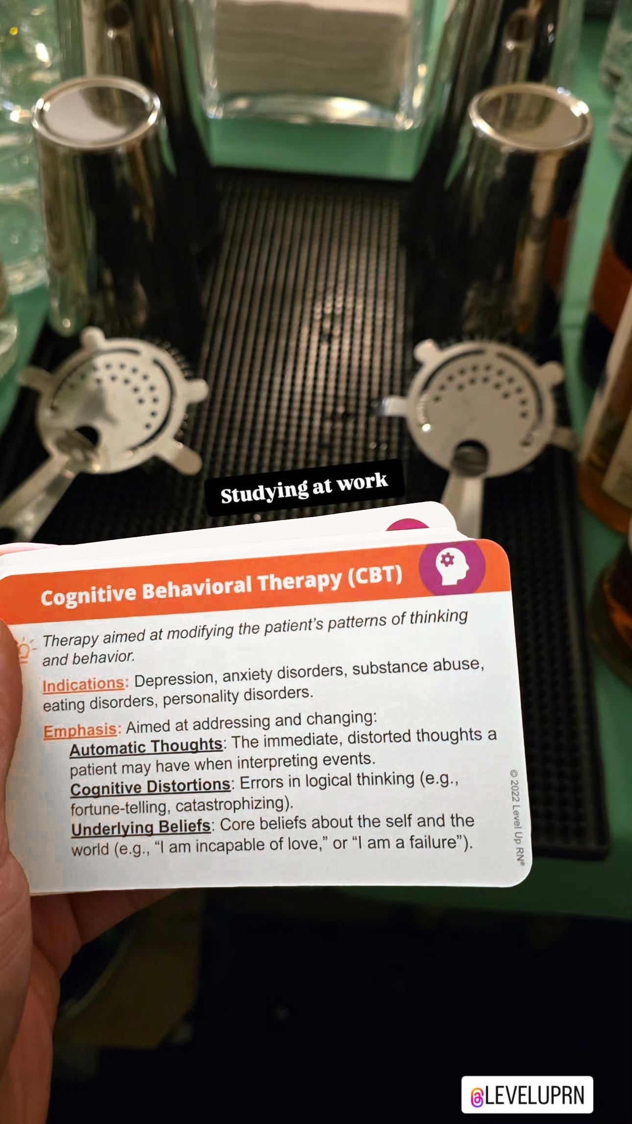 A hand holding the cognitive behavioral therapy flashcard