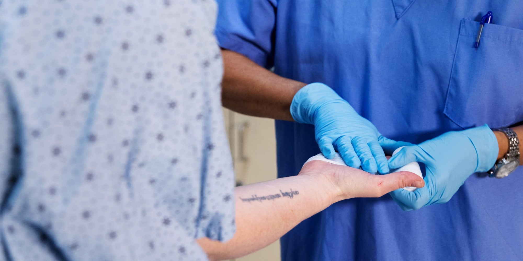 clinical skills - a HCW touching a patient's hand with a glove on