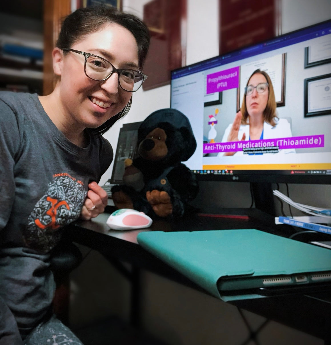 Sierra chilling with a stuffed dog watching Cathy on the screen