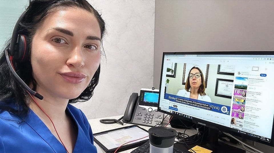 Holly watching level up rn cathy parkes medical surgical videos with a headset, sitting at a desk.