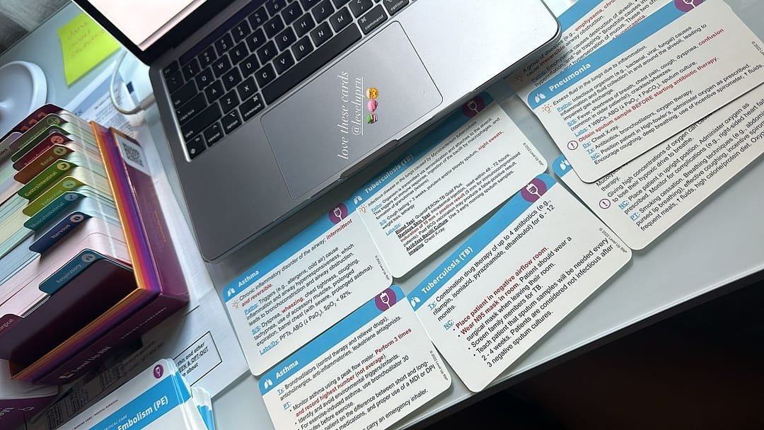 Medical-Surgical Nursing - Flashcards spread out on a table next to a laptop