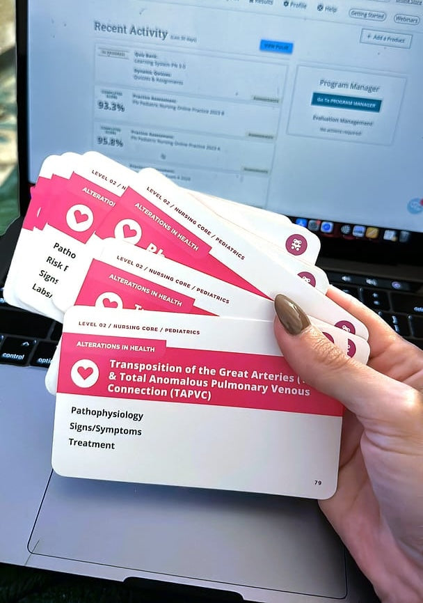 Hand holding Pediatric Nursing - Flashcards in front of a computer screen showing high nursing test scores